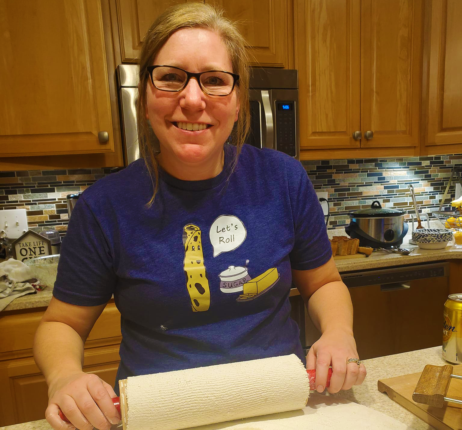 Carla - Baker - Owner of Sunflower sweets.  Baking lefsa - Shirt has lefsa roll stating "Let's Roll"