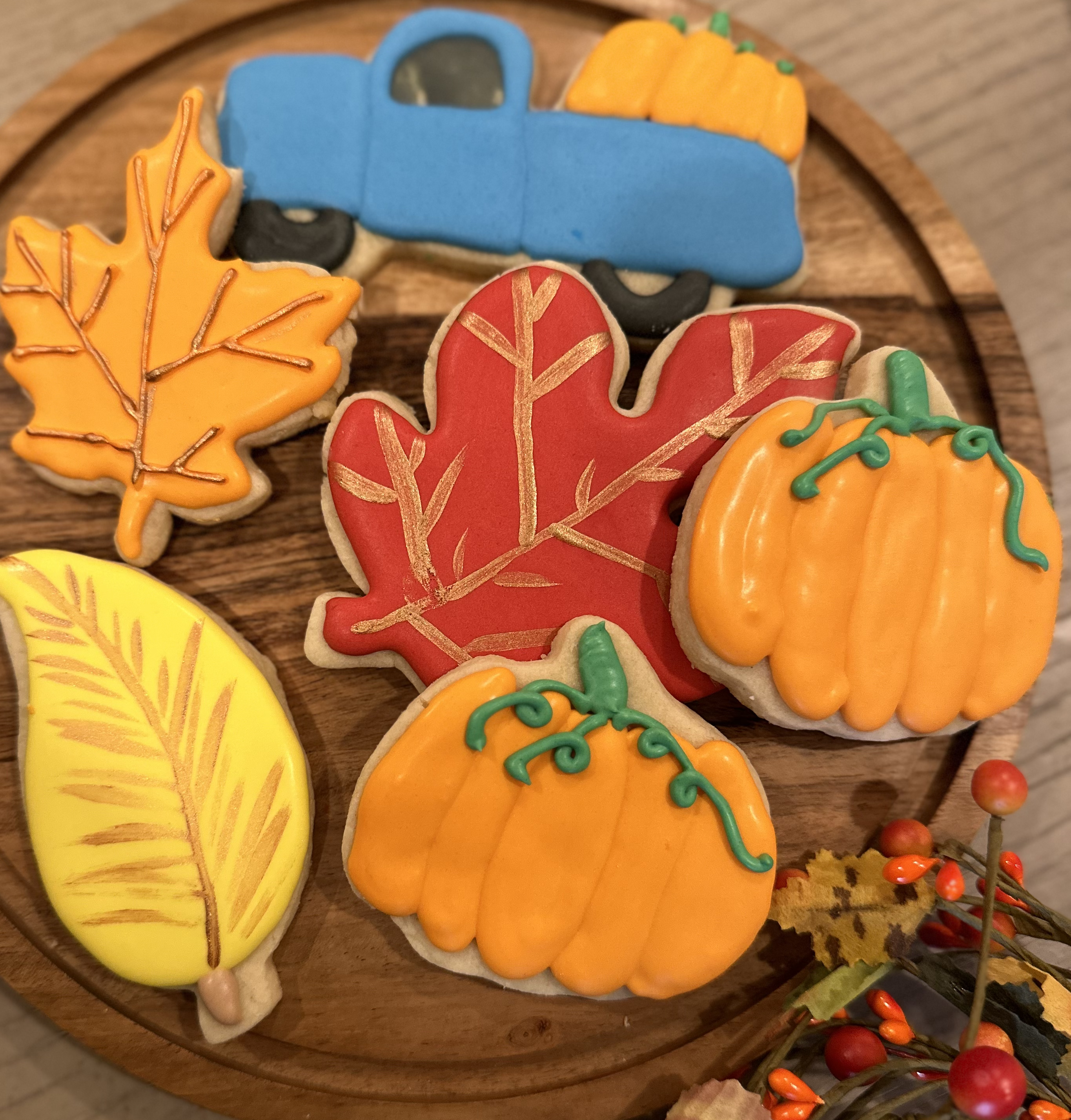 Truck with a large pumpkin in the back. Leaves and Pumpkin Cookies.